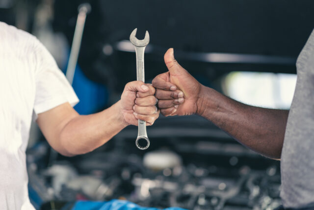 Garage worker mechanic thumb up hand with tool. Finished Work Job Done good fix repair automobile car engine service concept.